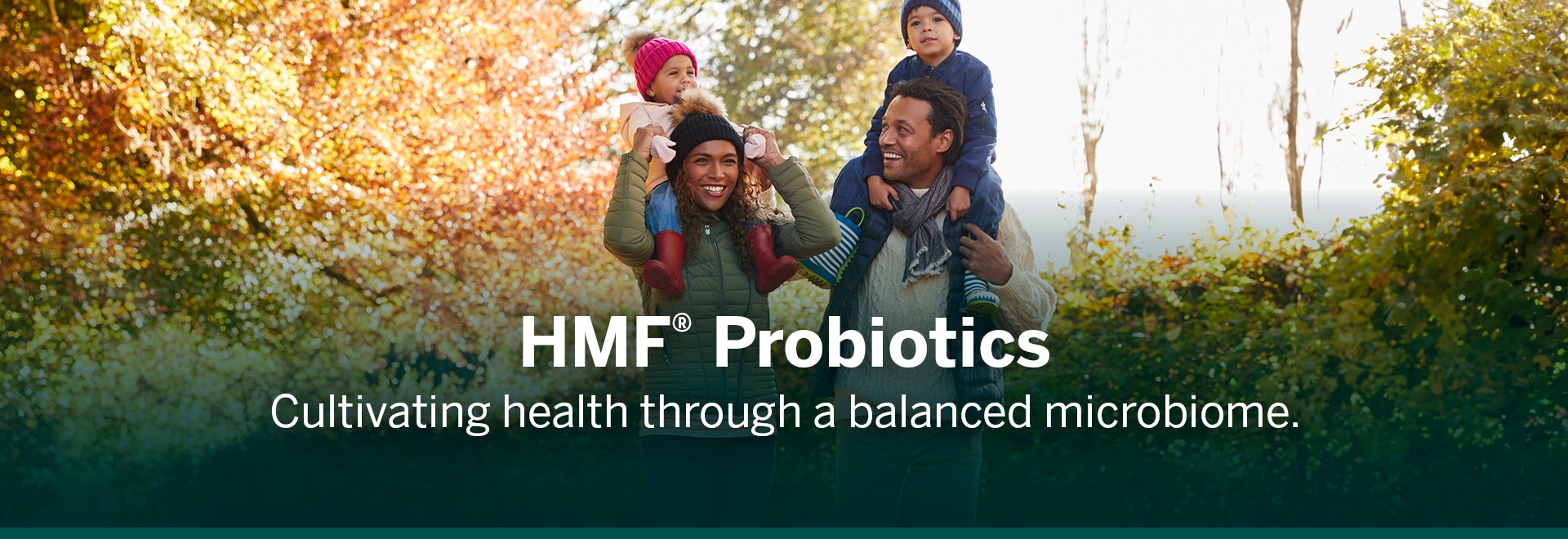 Family walking outside and smailing and launghing. The husband and wife are holding both kids on their shoulders and text says HMF Probiotics cultivitaing health through a balanced microbiome.