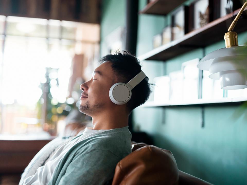 a-man-wearing-headphones-and-sitting-on-a-couch